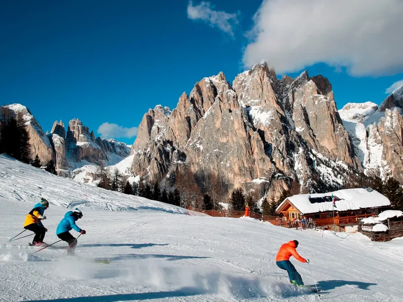 Skiers on the snowy slopes under the Dolomite peaks