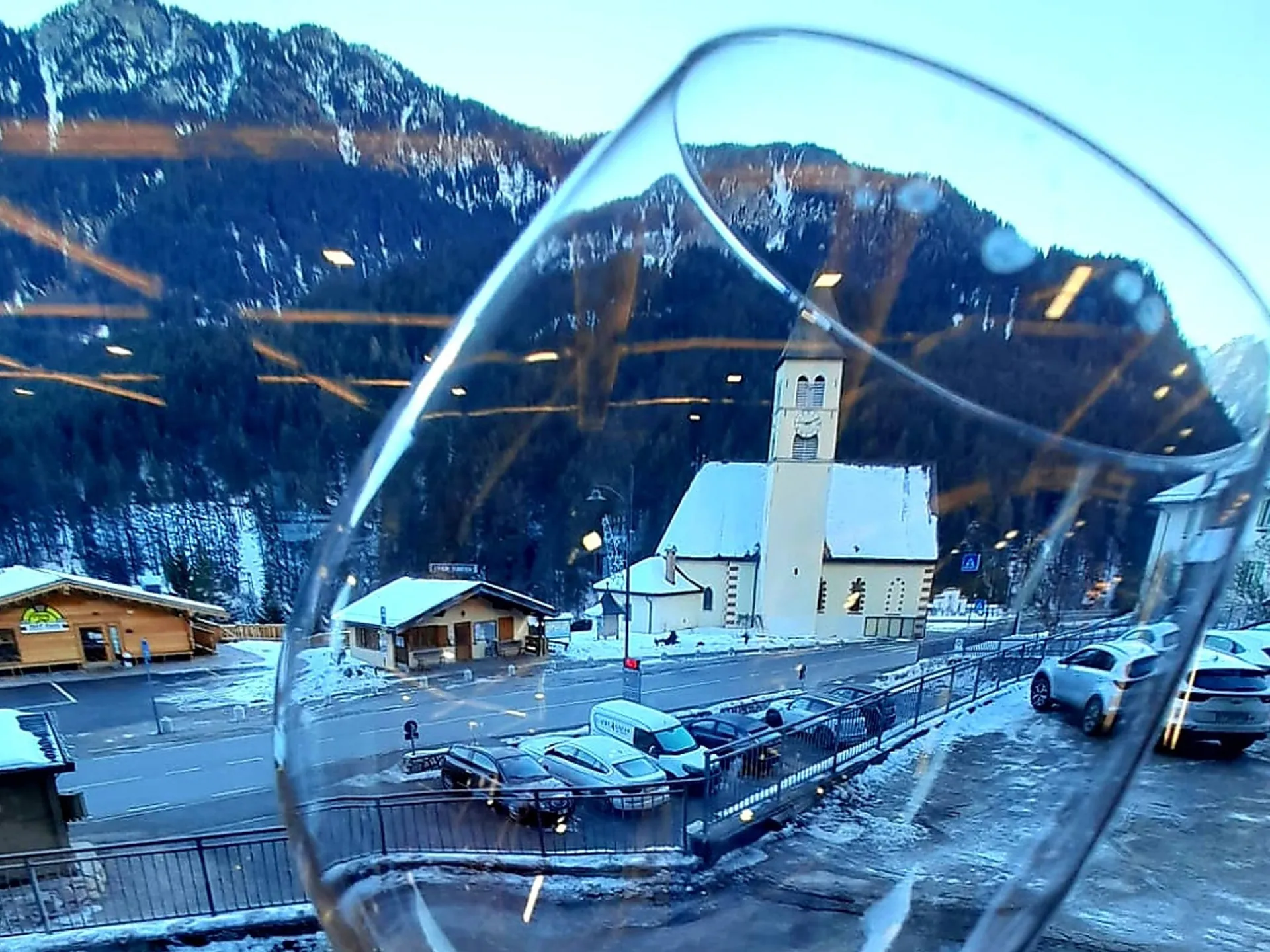 Mazzin and its church reflected in a glass of wine